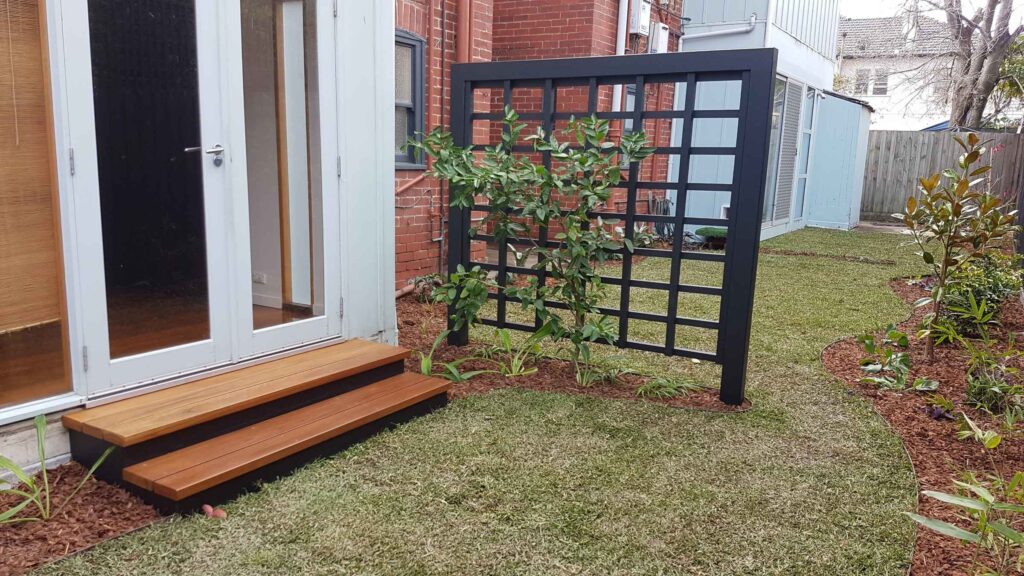 Curved steel edging and custom steel landscape work integrated with planting and an outdoor deck